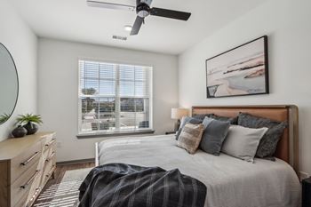 A bedroom with a bed and a ceiling fan